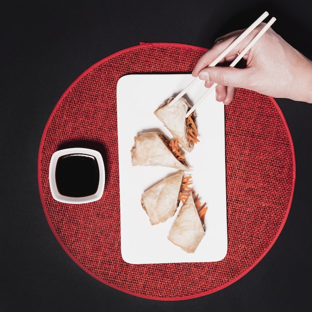 Free photo crop hand taking roll from plate