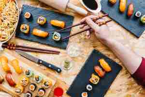 Free photo crop hand taking sushi from board