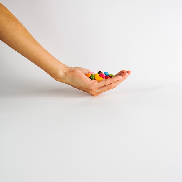 Crop hand with candy drops