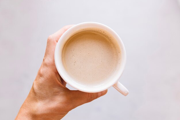 Crop hand with coffee cup