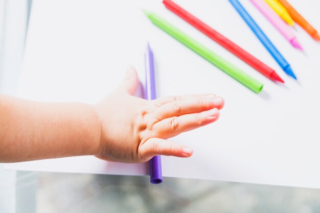Crop hand with crayons