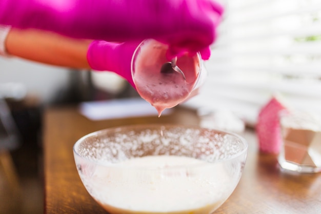 Crop hands adding yogurt to batter