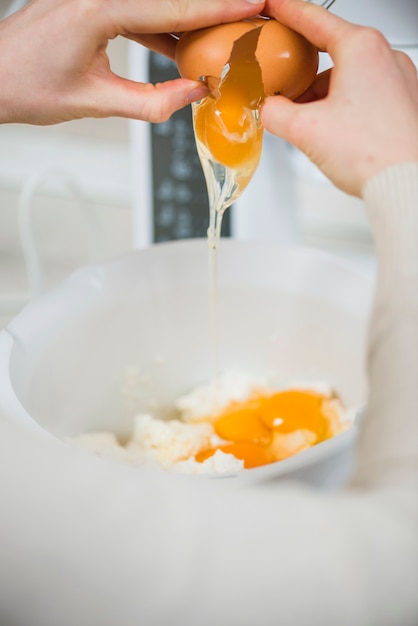 Crop hands breaking egg