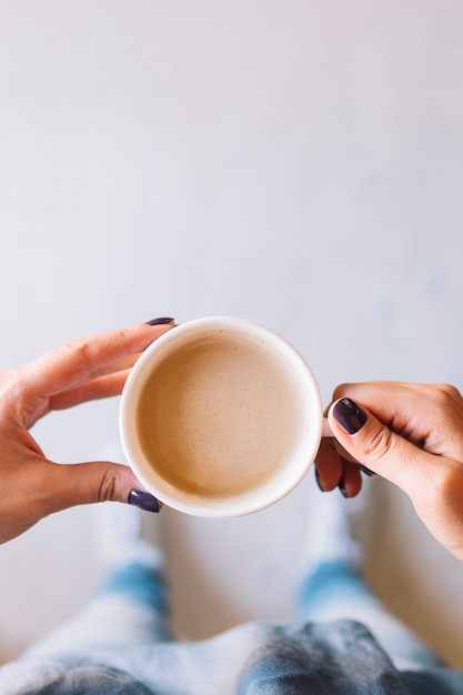 コーヒーカップを持って作物の手