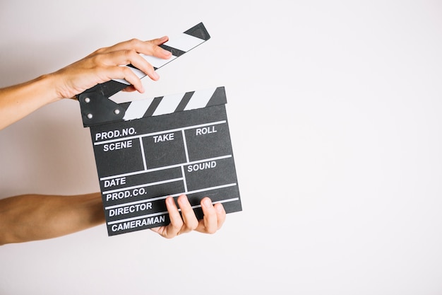 Crop hands clapping clapperboard