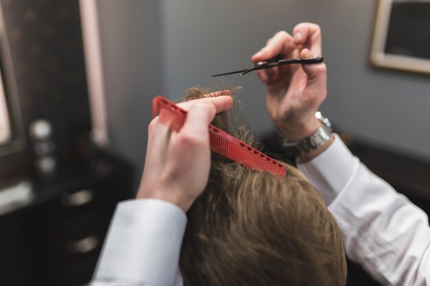 Crop hands cutting hair