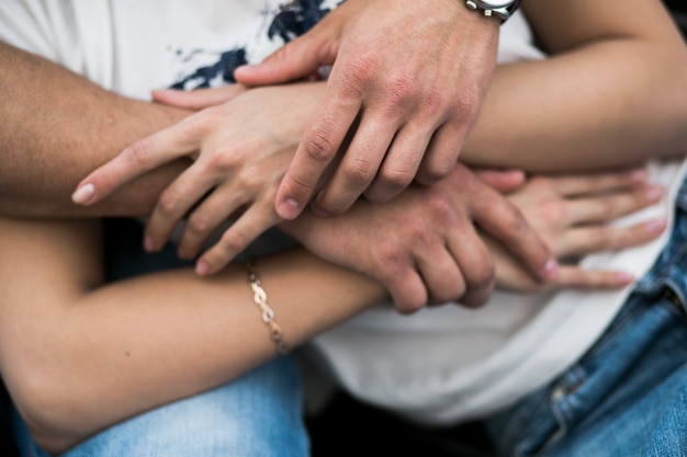 Crop hands of embracing couple