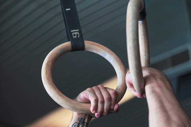 Foto gratuita ritaglia le mani sugli anelli da ginnastica