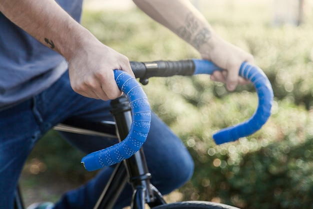 Crop hands on handlebar of bicycle