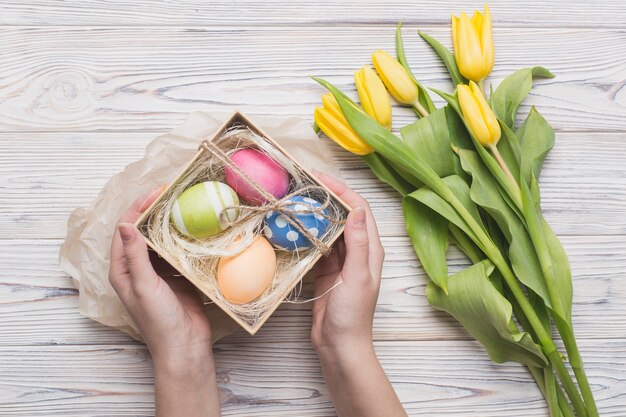 Free photo crop hands holding colored eggs