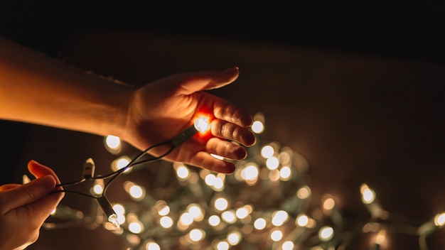 Free photo crop hands holding fairy lights