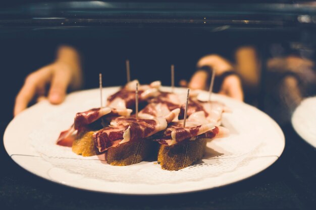 Crop hands holding meat tartines