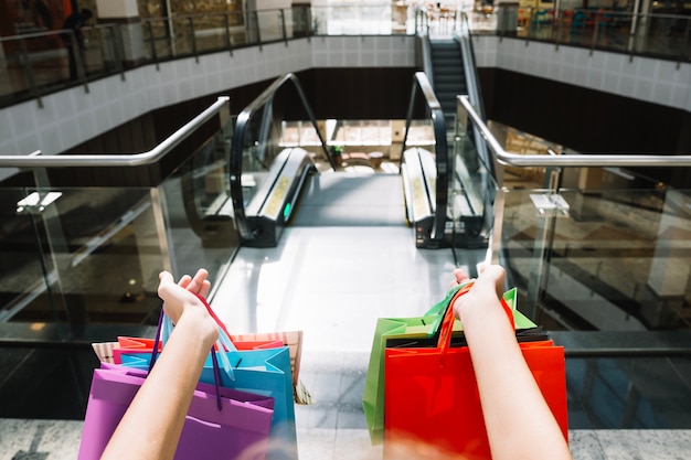 Free photo crop hands holding paper bags