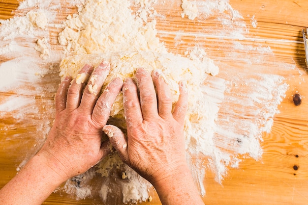 Crop hands kneading dough