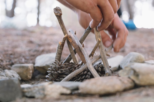 Crop hands making bonfire