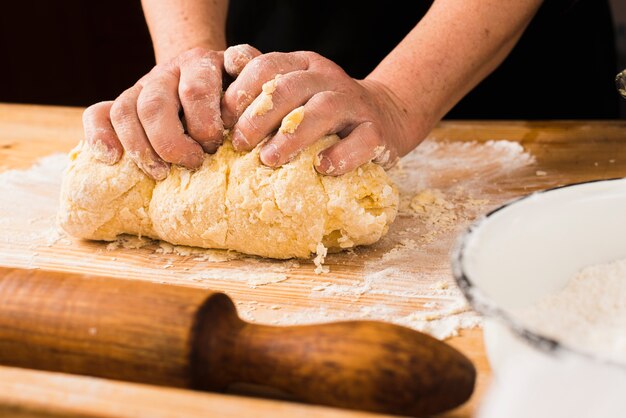 Crop hands making dough