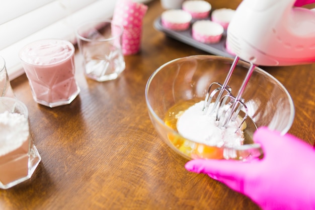 Crop hands mixing eggs and batter