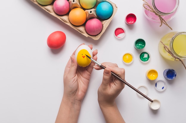 Foto gratuita ritaglia le mani che dipingono il pulcino sull'uovo