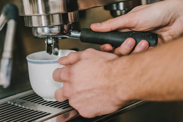 Foto gratuita ritaglia le mani versando il caffè