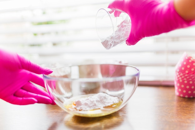 Free photo crop hands spilling flour into bowl