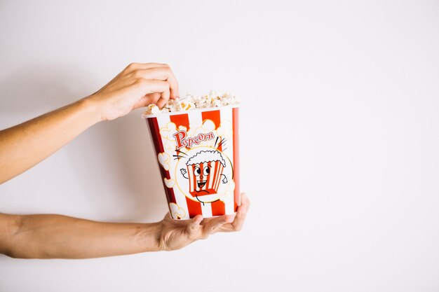 Crop hands taking popcorn