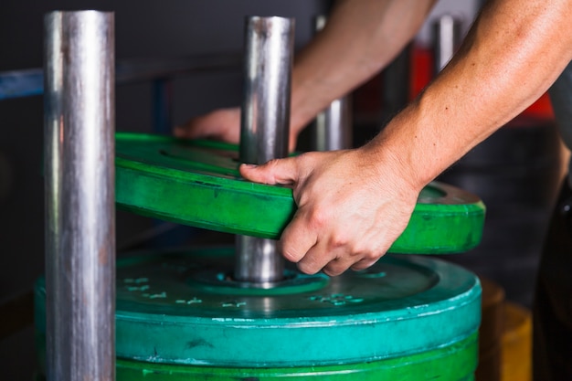 Free photo crop hands taking weight for dumbbell