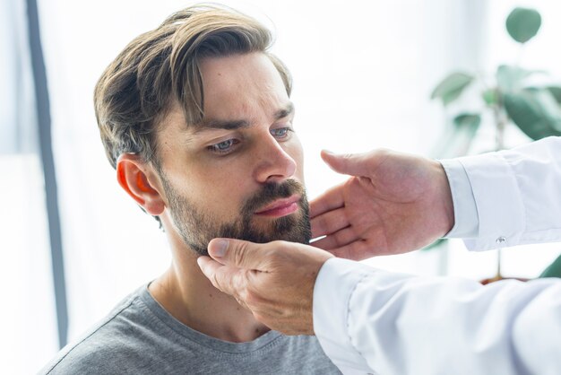 Crop hands touching lymph nodes of patient