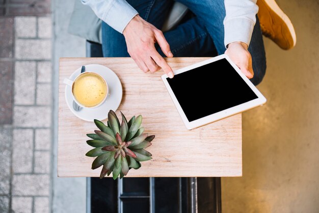 Crop hands using tablet in minimalistic surroundings