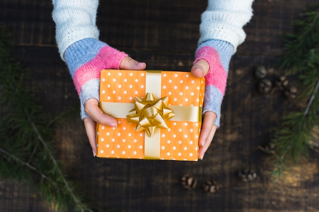 Foto gratuita ritaglia le mani con il regalo di natale