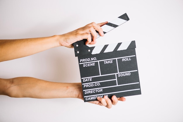 Crop hands with clapperboard