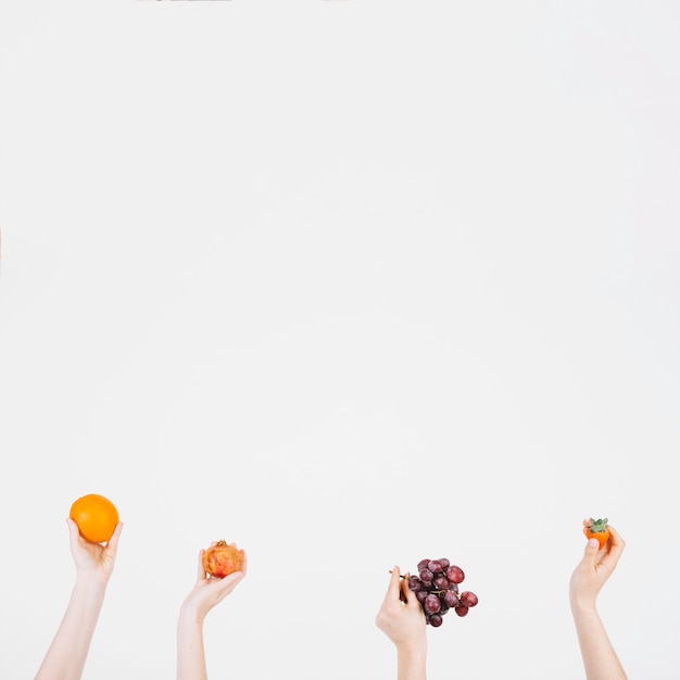 Crop hands with fruits