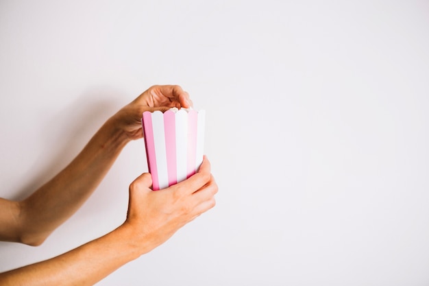 Crop hands with popcorn box