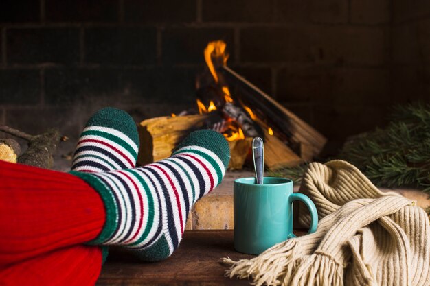 暖炉とスカーフの近くの脚と飲み物