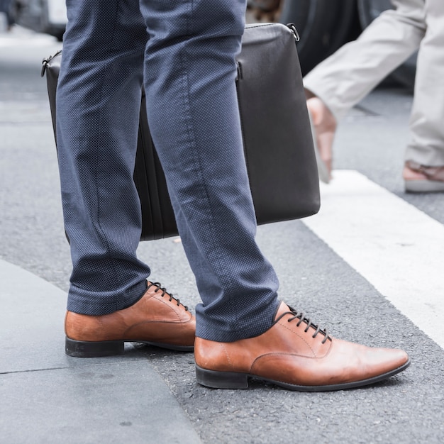 Free photo crop legs of businessman near road