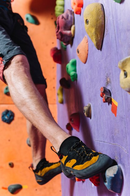 Crop legs climbing high wall