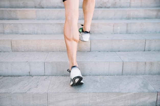 Free photo crop legs leaping on cement stairs