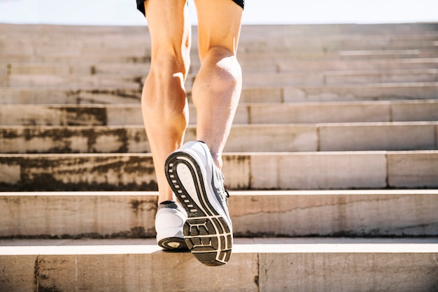 Foto gratuita ritagliare le gambe correndo al piano di sopra