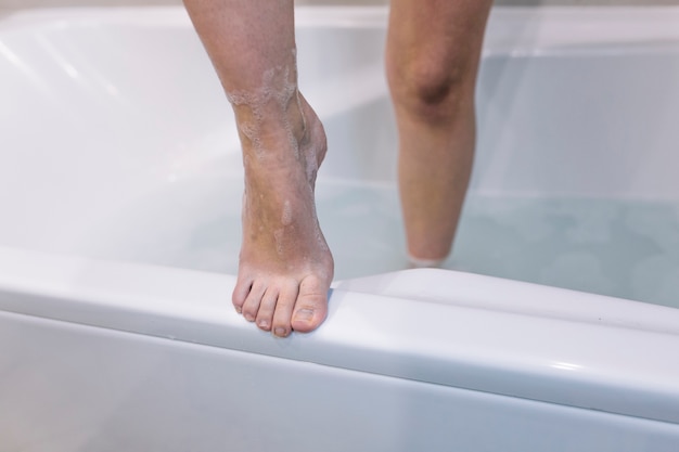 Free photo crop legs stepping out bath