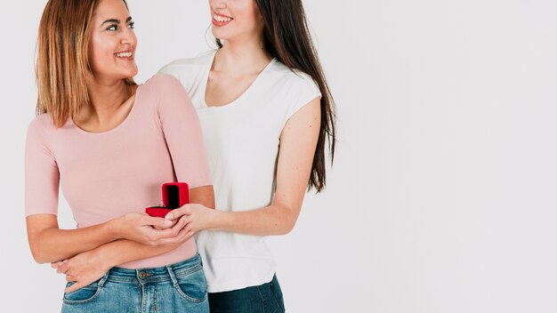 Crop lesbian couple with ring embracing