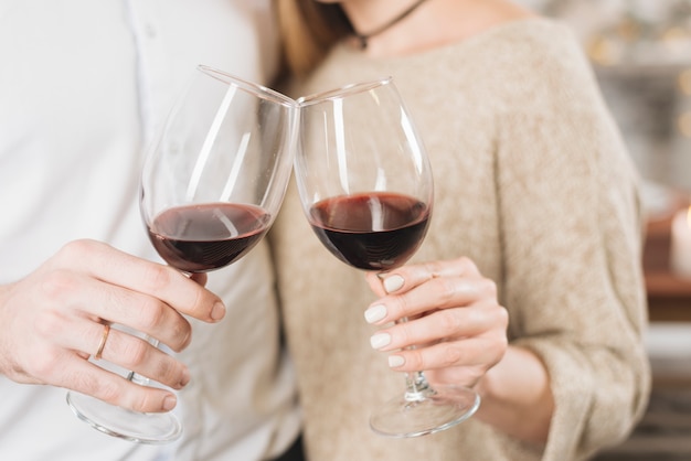 Crop loving couple clinking with wine