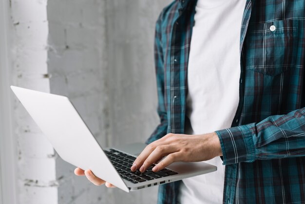 Crop man browsing laptop