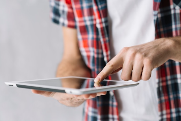 Crop man browsing tablet 