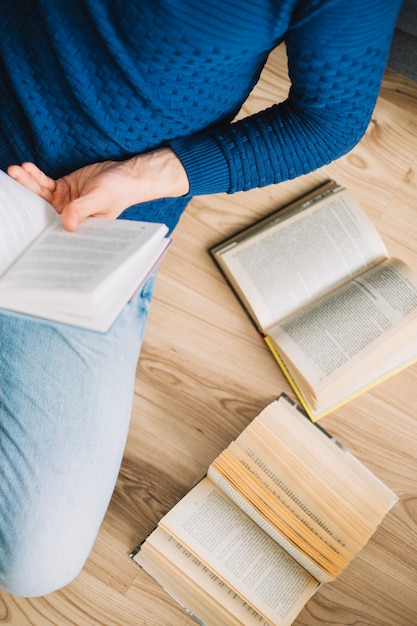 Free photo crop man enjoying reading on floor