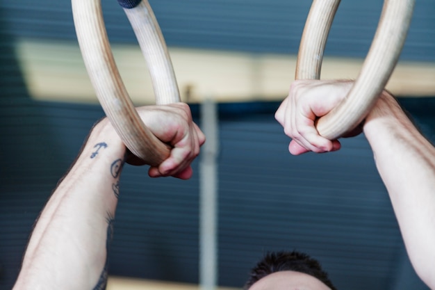 Foto gratuita raccolga l'uomo che si esercita sugli anelli relativi alla ginnastica