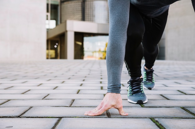 Crop man exercising on pavement