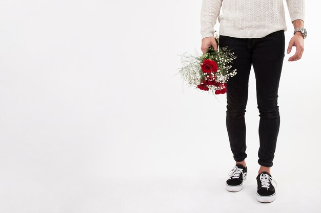 Crop man holding bunch of roses