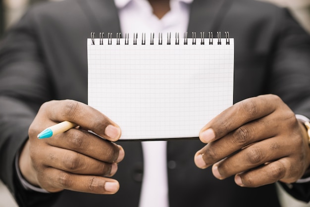 Crop man holding empty notebook