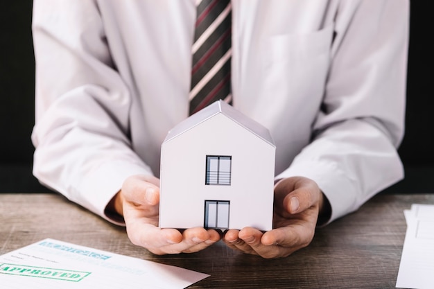 Free photo crop man holding paper house