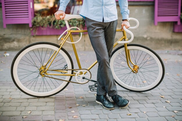 Crop man leaning on bike