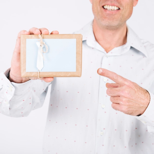 Crop man pointing at gift box